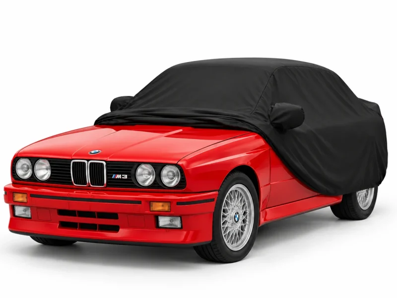 Housse extérieure Urban noire pour BMW X6 : housse repliée sur une BMW M3 E30, avant découvert