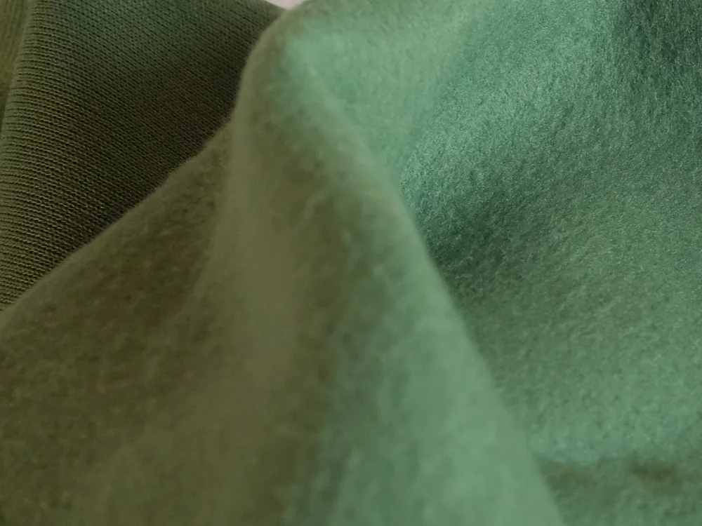Tissu Jersey vert froissé : le molleton reste mat et les plis s'arrondissent