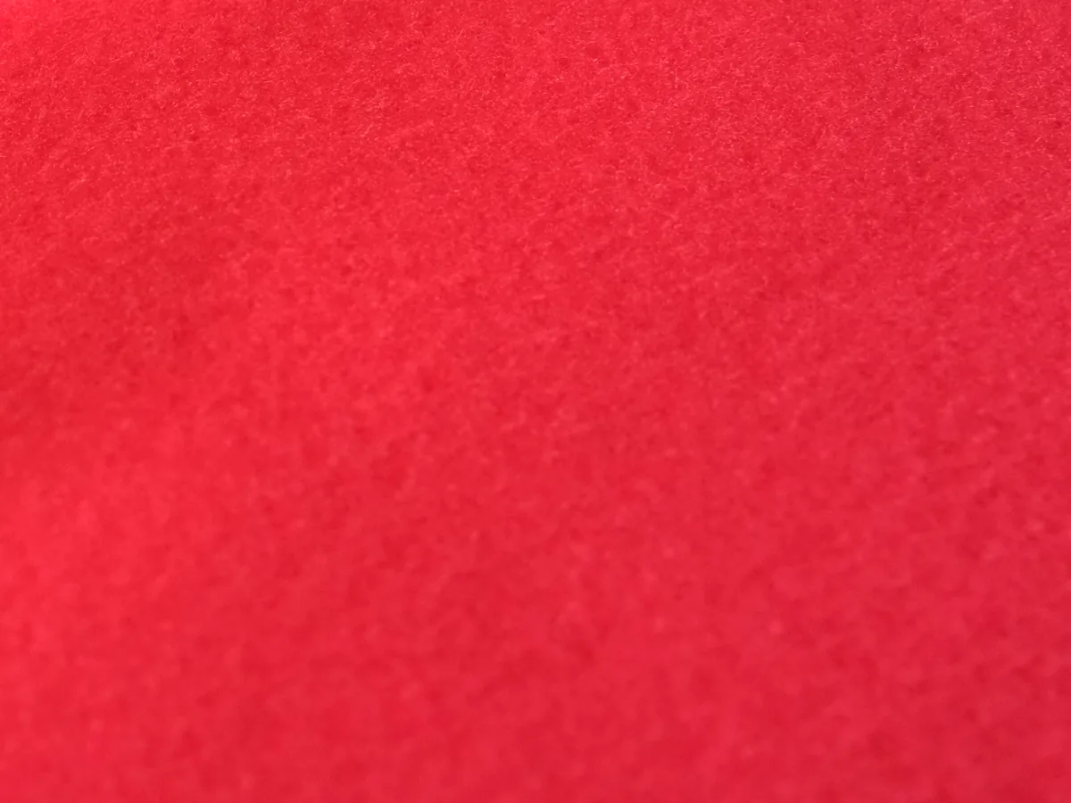 Gros plan du tissu Jersey rouge : face molletonnée, brossée et dense, sans trame visible